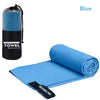 Blue microfiber towel rolled up on a blue fabric mat with a mesh pouch visible.