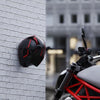 A black and red versatile multi-use wall hook is mounted on a white brick wall.