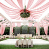 Pink sheer chiffon draping fabric creating a romantic ceiling canopy for an outdoor event.
