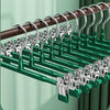 A close-up view of green and brown stainless steel adjustable clothing hangers arranged in a rack.