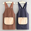 A brown striped waterproof sleeveless kitchen apron with a removable hand towel hanging on a wooden hanger.