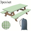 A set of three plaid tablecloths or mats, featuring a green and white checkered pattern, displayed with wooden supports.