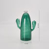 Un vase en verre vert translucide, haut, cactus avec surface texturée et petites protubérances.
