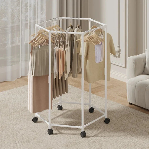 A white rotating hexagon clothes rack with wooden hangers displaying various garments in a bright indoor setting.