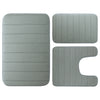 Ein Set aus drei grauen Memory-Foam-Badezimmerteppichen, bestehend aus einer rechteckigen Matte und zwei unregelmäßigen Forme