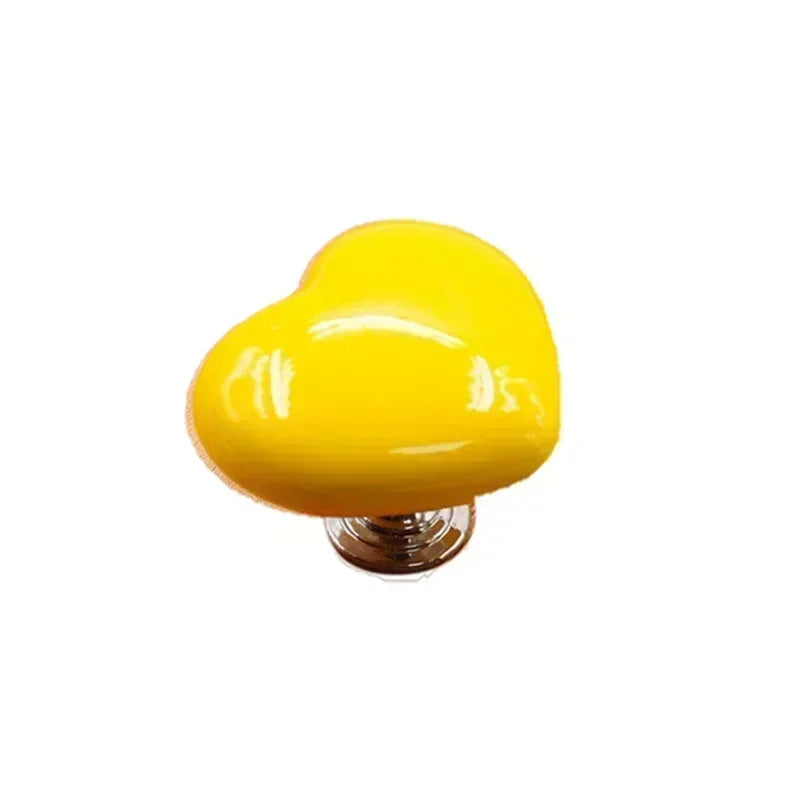 A bright yellow heart-shaped toilet presser button.
