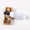 A black automatic transparent folding umbrella is shown next to a wooden box containing several small, spherical, light-color