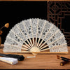 Elegant lace folding handheld fan with a light beige color displayed on a wooden surface.