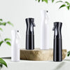 A set of black and white multi-functional handheld spray bottles displayed on a wooden surface.