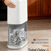 A white slim hands-free trash can with a clear lid is shown next to wooden cabinets.