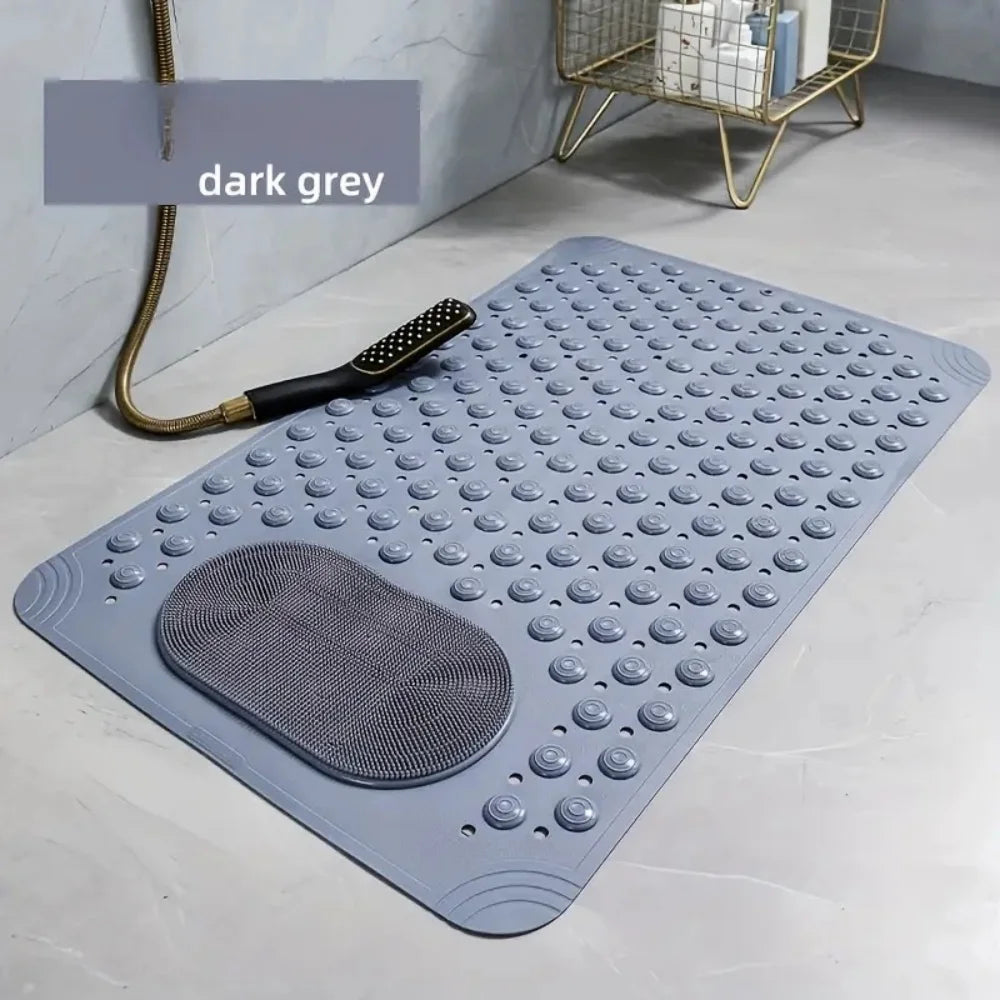Una estera de baño de masaje gris oscuro antideslizante mostrada sobre una superficie clara junto a una herramienta de masaje