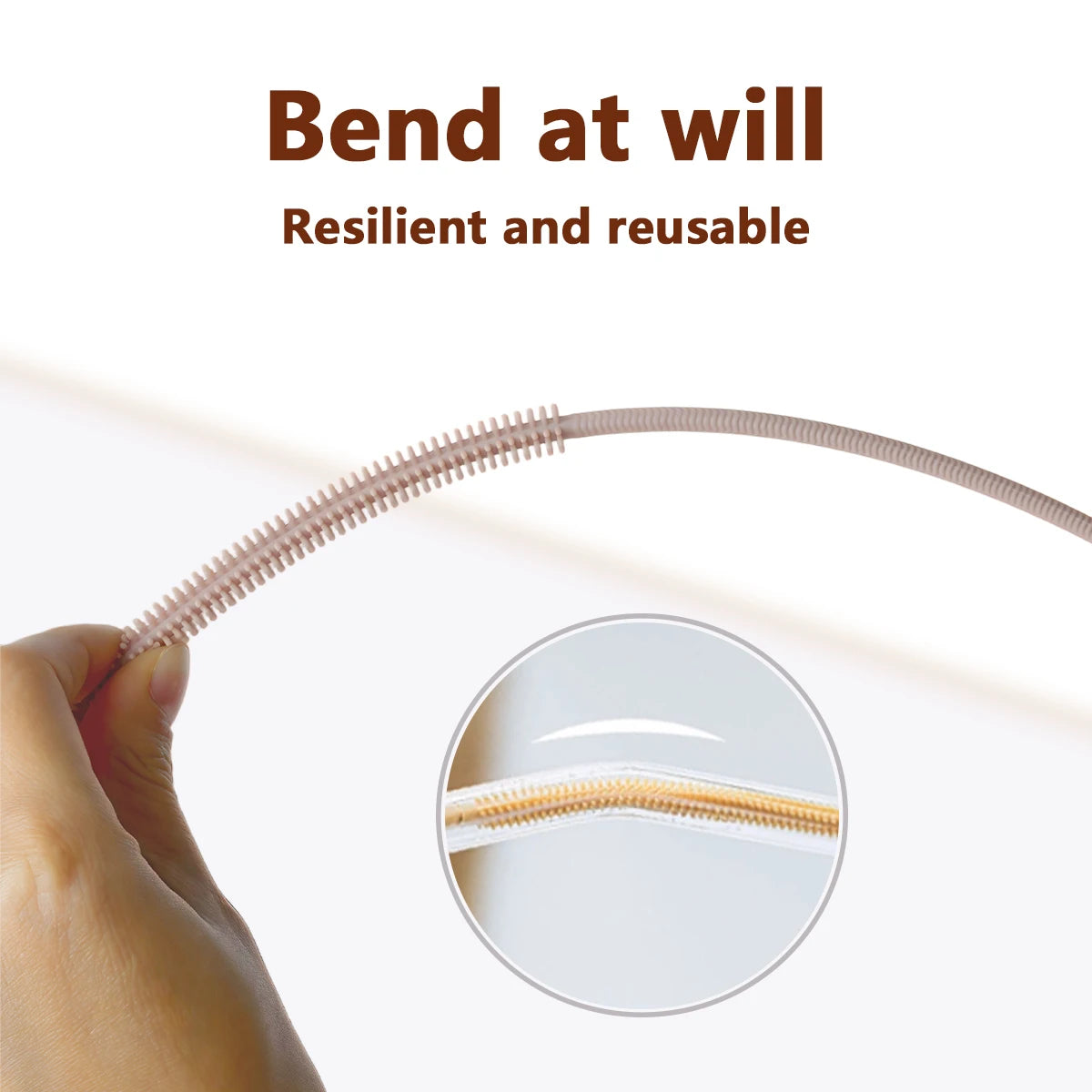 A hand is bending a silicone straw cleaning brush, showing its resilient and reusable nature.