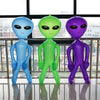 Three inflatable alien decorations in blue, green, and purple standing on a reflective floor.