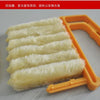 A close-up view of a yellow multi-functional cleaning brush with several white bristles, used for cleaning blinds and crevice