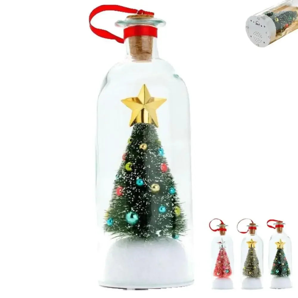 A clear glass bottle filled with sparkling white material and decorated with a gold star and a green Christmas tree.
