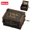 A wooden music box with a lid featuring the text A Bela Féra and an attached hand crank.