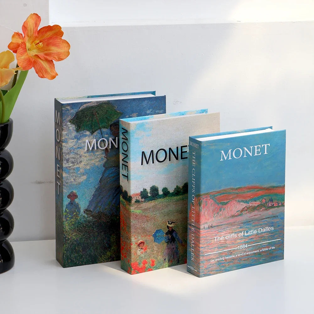 A stack of three decorative fake books titled Monet featuring landscapes and art