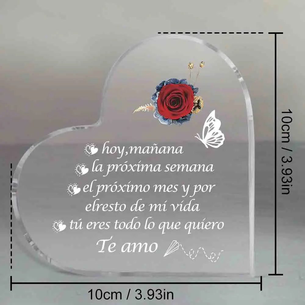 Placa de acrílico transparente en forma de corazón grabada con una rosa roja y texto en español que expresa amor