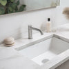 Moderne Badezimmerschminktisch mit rechteckigem weißem Waschbecken und Chromarmatur, mit Reinigungsprodukten und Dekoration