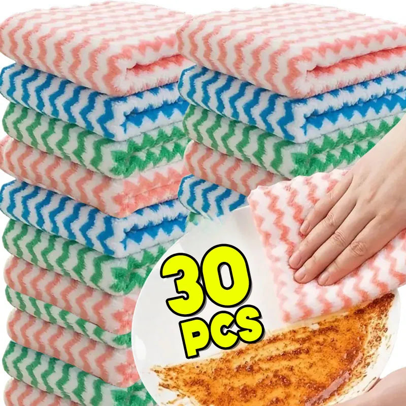 A stack of pink and green coral fleece cleaning cloths with blue stripes is shown next to a piece of orange food.