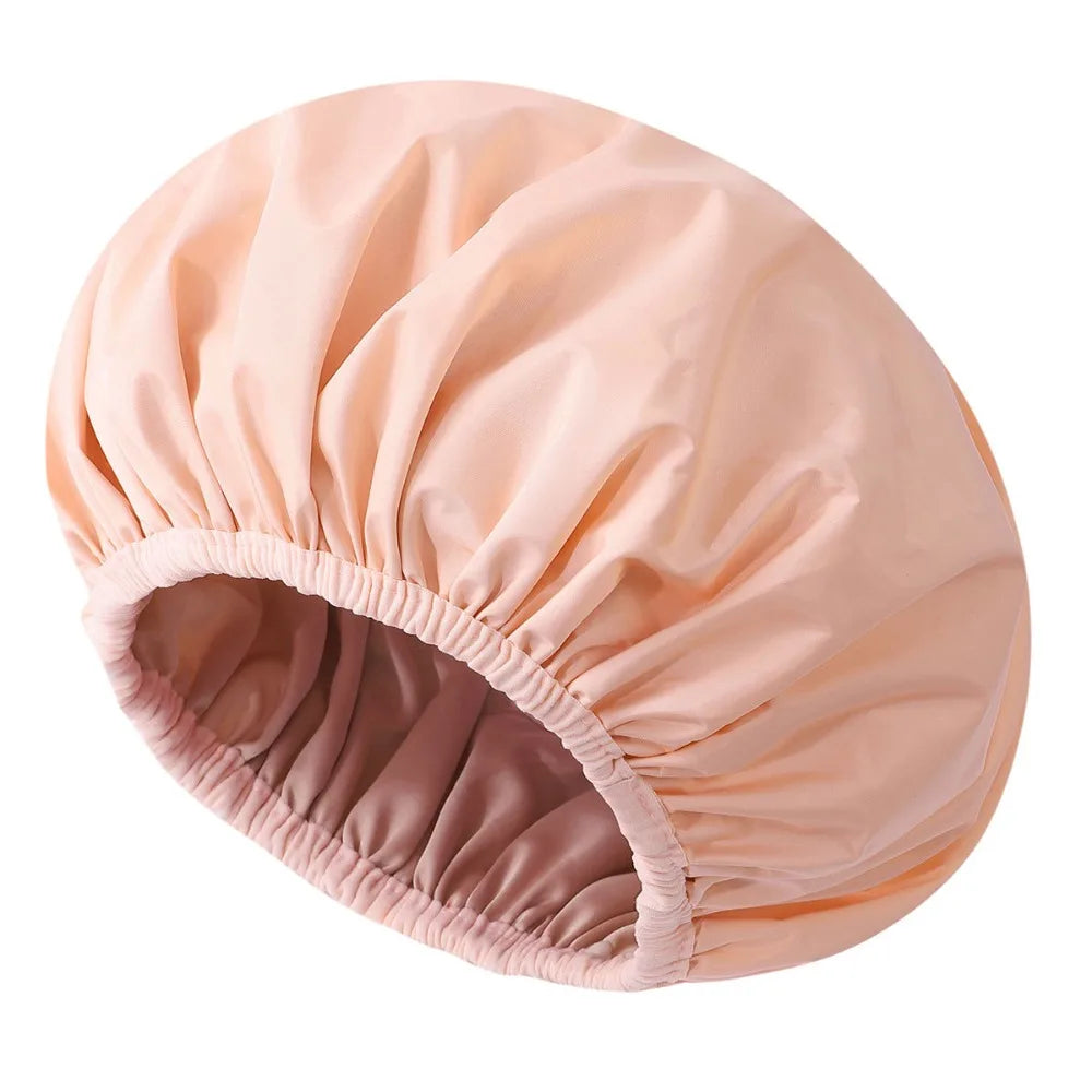 A light peach reusable satin lined shower cap shown from the side.