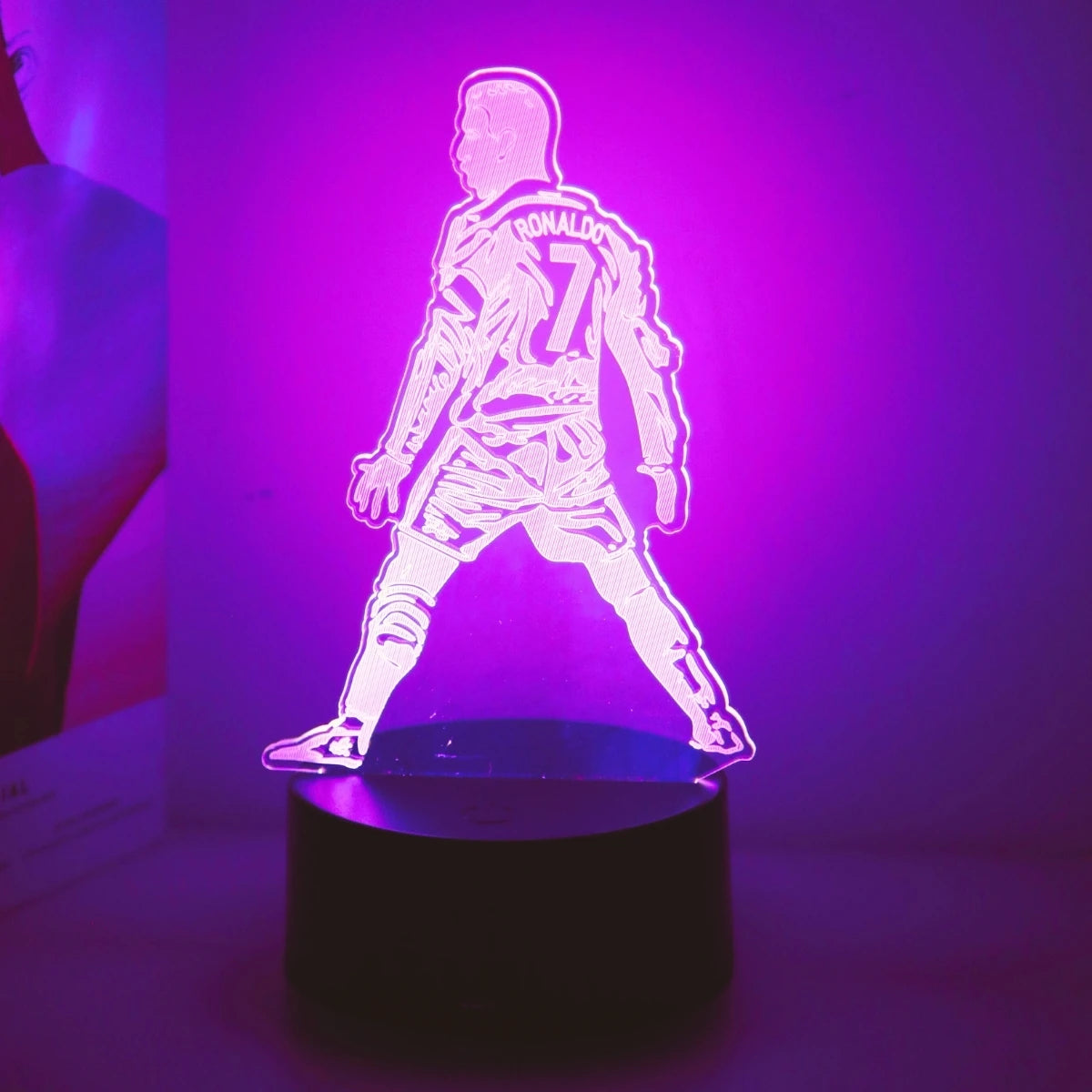 A glowing 3D touch night light sculpture of Cristiano Ronaldo in a dynamic pose against a purple background.