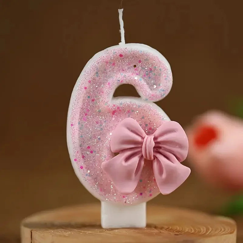 Pink glitter number six candle with a pink bow on a white stick