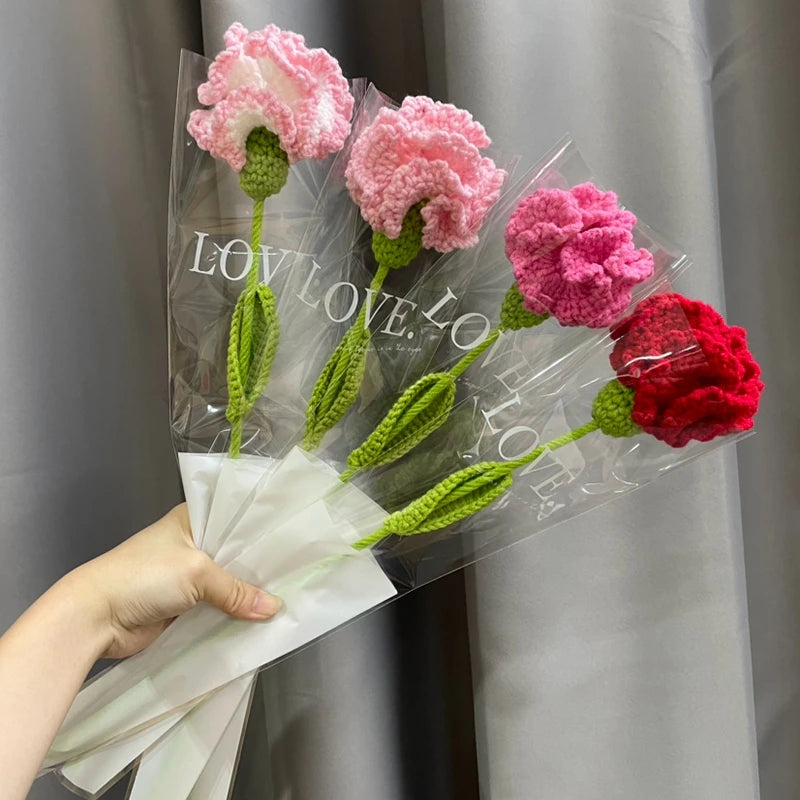 Un bouquet de cœurs de coton faits main, roses et rouges, emballés dans du cellophane transparent.