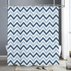 A shower curtain featuring a blue and white chevron pattern hanging on a metal rod.