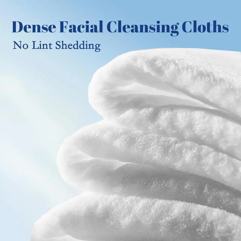 Close-up of thick white facial cleansing cloths showing soft texture and folds.