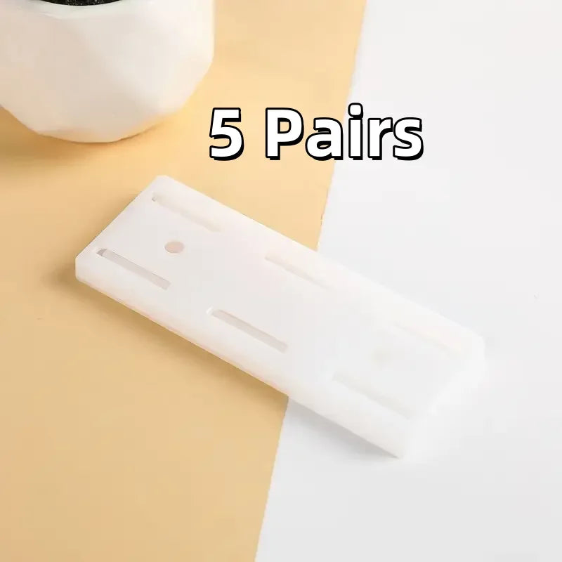 Five pairs of white self-adhesive desktop cable organizer holders shown on a light background.