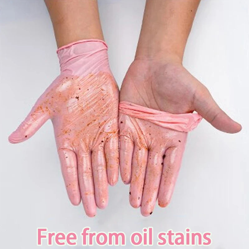 A pair of pink nitrile cleaning gloves are shown on a hand, demonstrating they are free from oil stains.