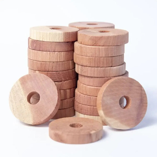 A stack of round, light brown wooden blocks used as natural cedar deterrents for pests.