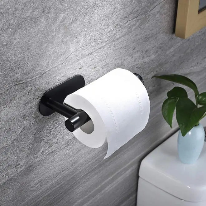 A black stainless steel self-adhesive toilet paper holder with a white roll mounted on a gray wall.