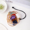 A set of seven crystals in gold wire rings suspended on a black leather cord.