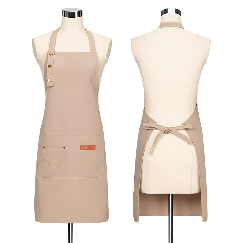 A beige canvas apron displayed on a mannequin, featuring adjustable straps and a front pocket.