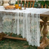 White lace retro tablecloth draped over a wooden table outdoors