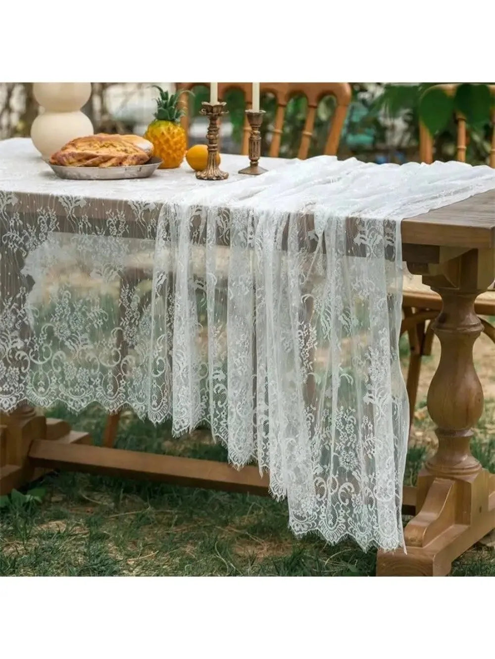 White lace retro tablecloth draped over a wooden table outdoors