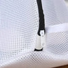 Close-up of a white mesh laundry bag for shoes and delicates featuring a black zipper.