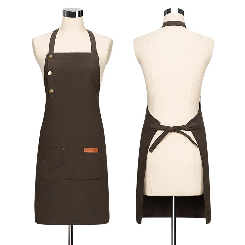A dark brown canvas apron displayed on a mannequin, featuring adjustable straps and a tie closure.