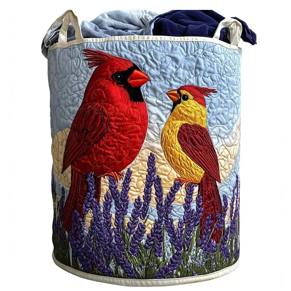 A quilted laundry basket with handles featuring embroidered birds in red and yellow against a light blue background.