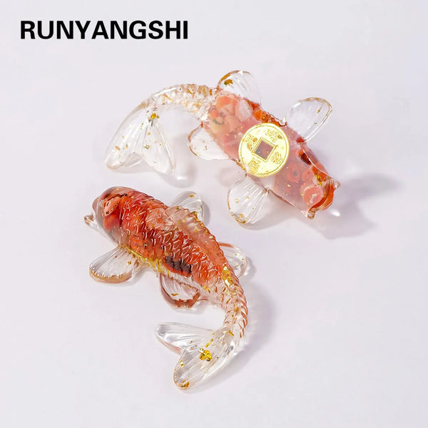 A small, reddish-orange crystal goldfish statue with a gold coin detail.