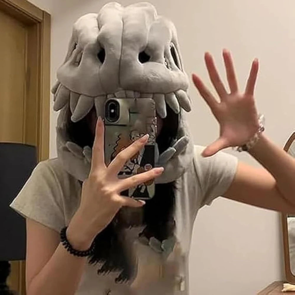A person wearing a dinosaur skeleton costume is taking a selfie with a smartphone.