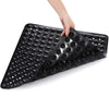 A hand is placing a black non-slip shower mat with suction cups onto a surface.