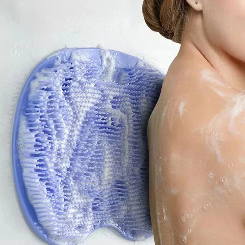 Una estera de ducha de masaje de pies de silicona azul junto al hombro de una persona, con residuo blanco en la piel.