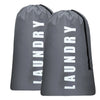 Dos bolsas de ropa grises con letras blancas, de pie.