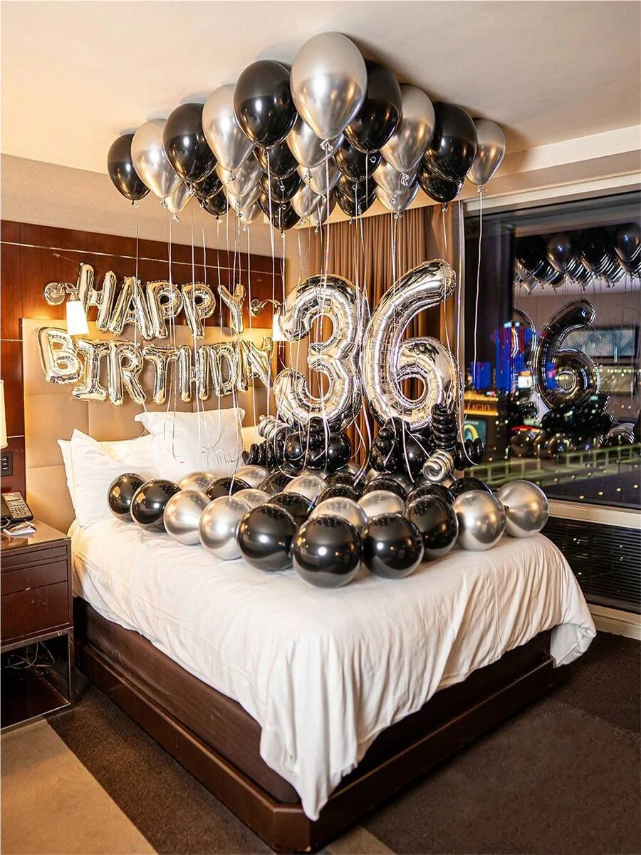 Guirnalda de globos metálicos plateados y negros con el número treinta y seis sobre una cama.
