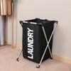 A black foldable laundry basket with a silver frame is standing on a light-colored floor.