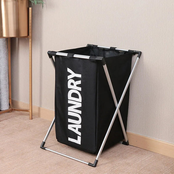 A black foldable laundry basket with a silver frame is standing on a light-colored floor.