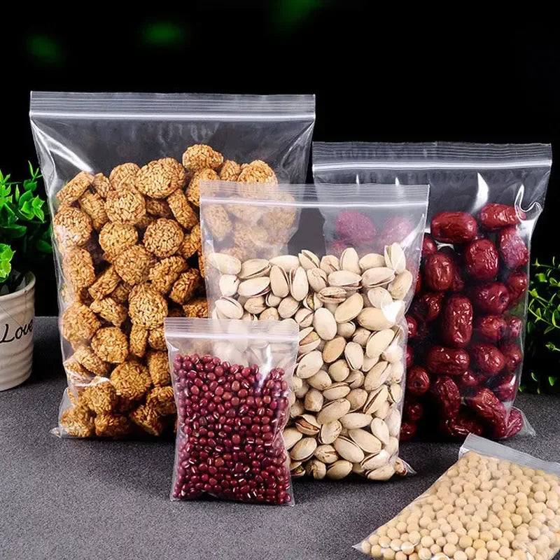 Varias bolsas ziplock transparentes llenas de semillas y granos secos como semillas de calabaza, lino y frijoles rojos